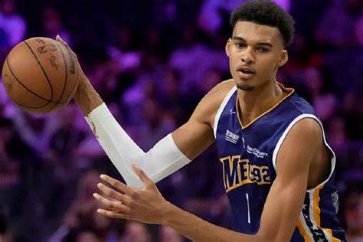 Victor Wembanyama hands Photos of NBA Draft pick holding stuff